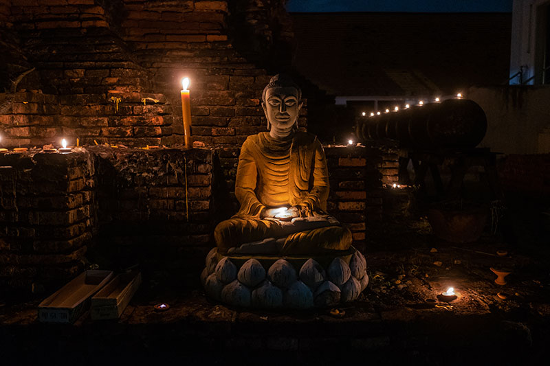 Buddha statue surrounded with candles