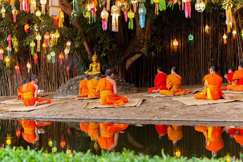 Monks sitting and praying under banyan tree on Vesak